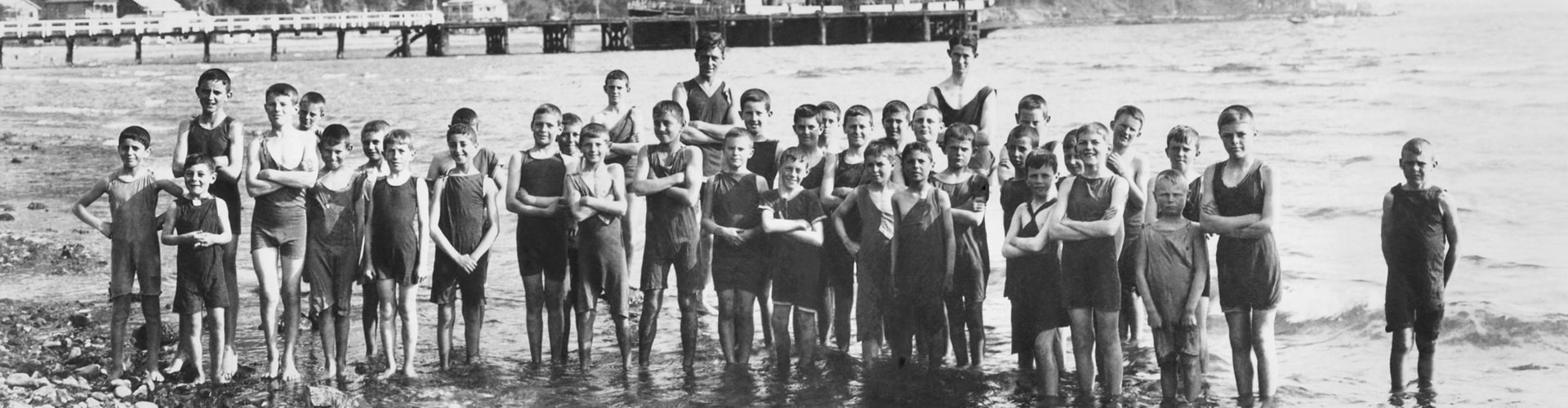 Boys Croydon Standing in bay with boat and wharf in background